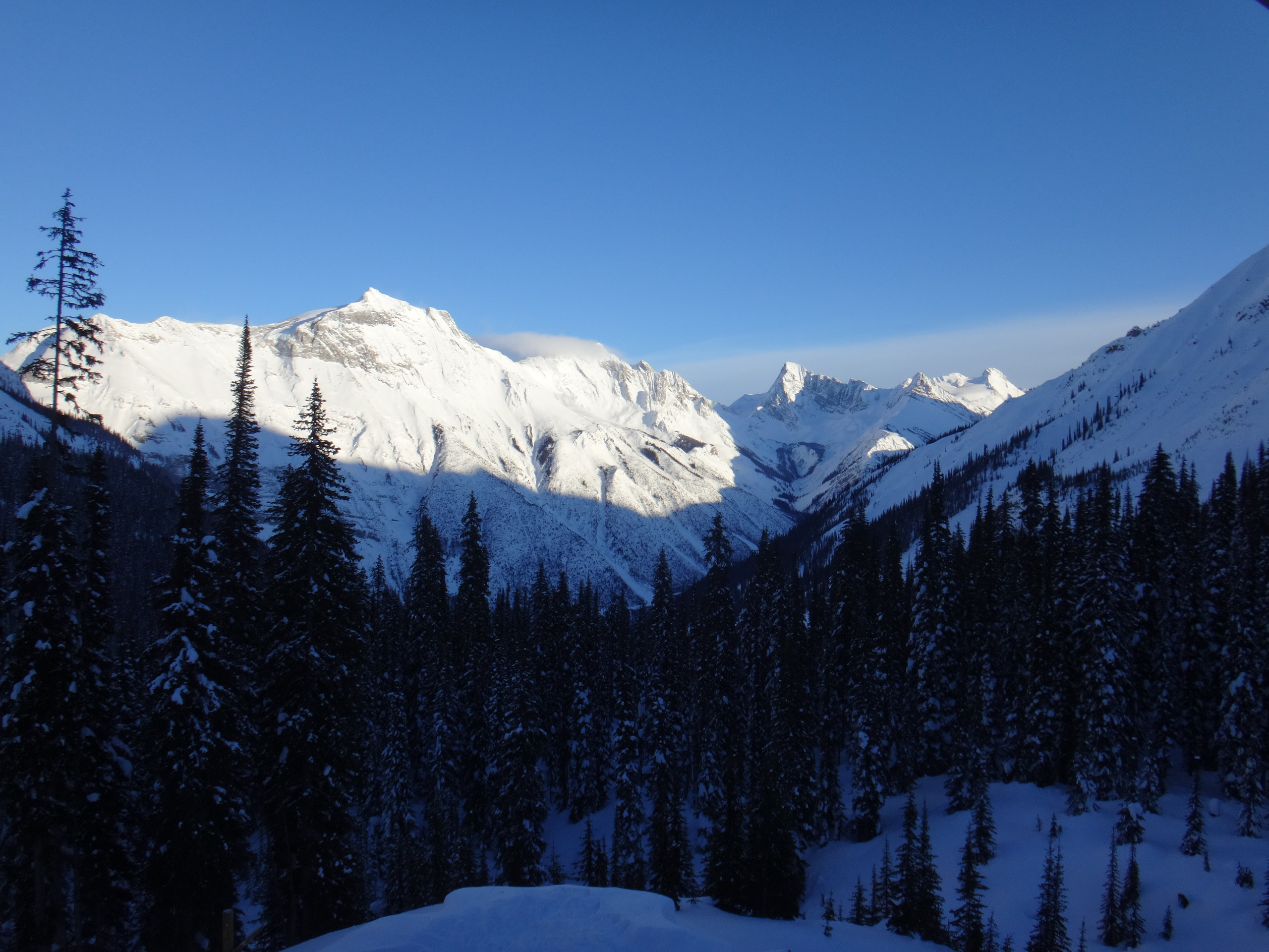 Sunlit alpine peaks above a snowed-in valley